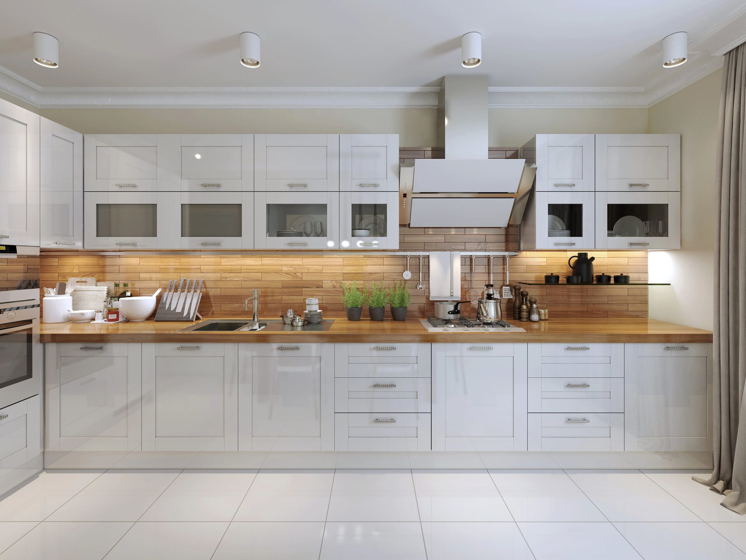 Modern kitchen with white cabinets, wooden countertops, and stainless steel appliances. The backsplash is a warm, light brown tile. Multiple small plants, jars, and kitchen essentials are neatly arranged along the countertops. The floor is tiled in white.